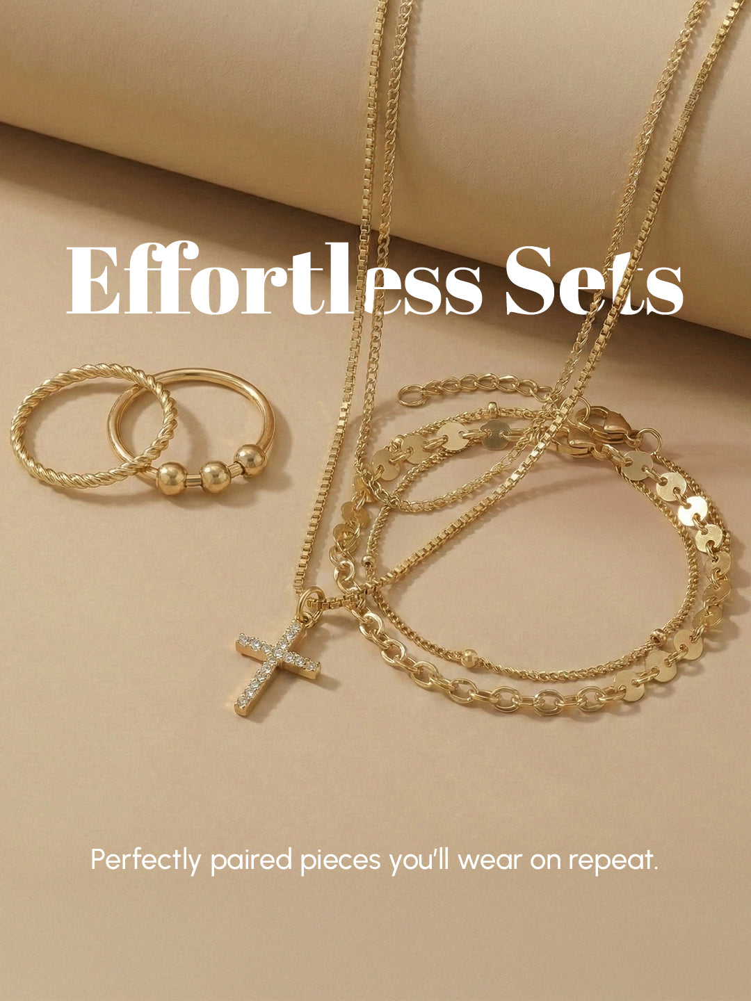 Gold jewelry set including necklace, bracelet, and ring on a beige background with text 'Effortless Sets'.
