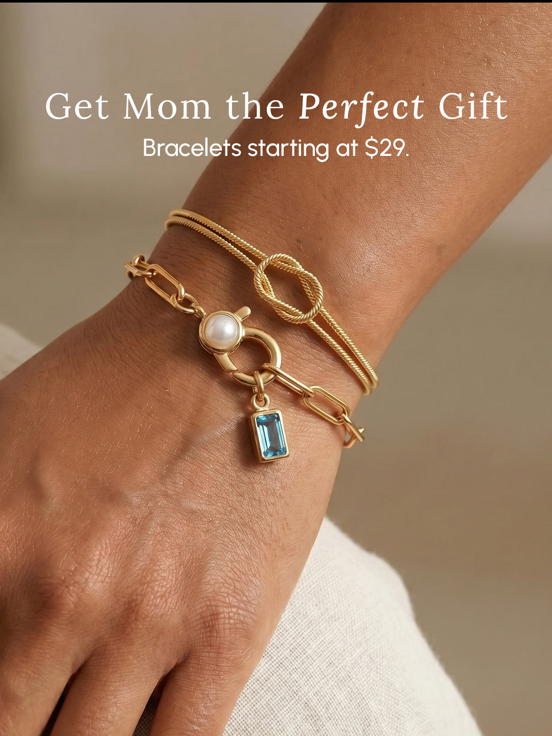 Gold bracelet with a pearl and blue gemstone charm on a wrist, with promotional text about gift ideas for mom.