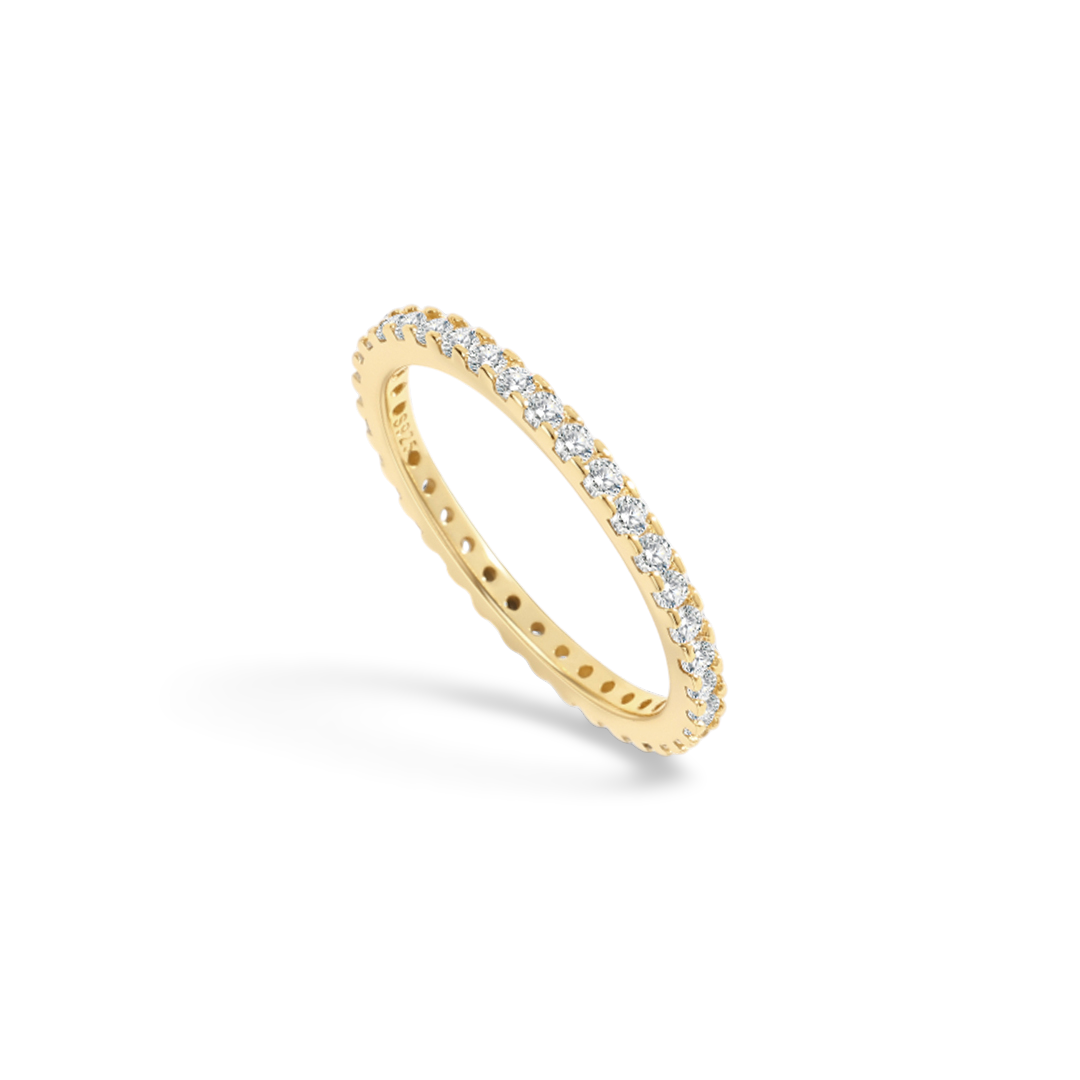 Gold ring with small diamonds on a light gray background