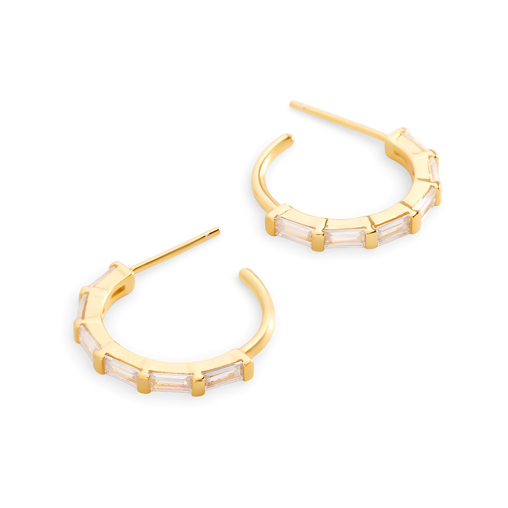 Gold hoop earrings with clear gemstones on a light gray background