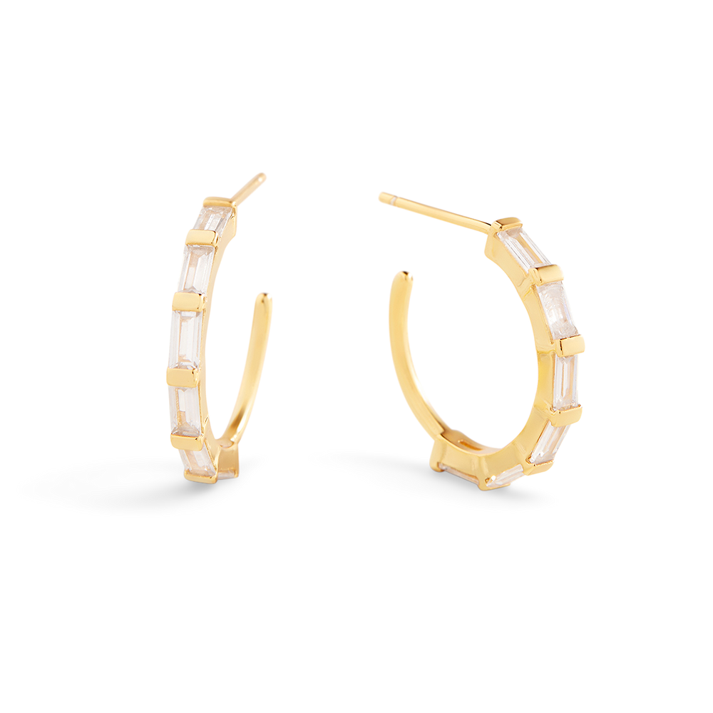 Gold hoop earrings with clear gemstones on a white background