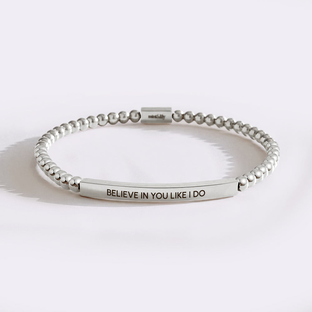Silver beaded bracelet with engraved message on a white background