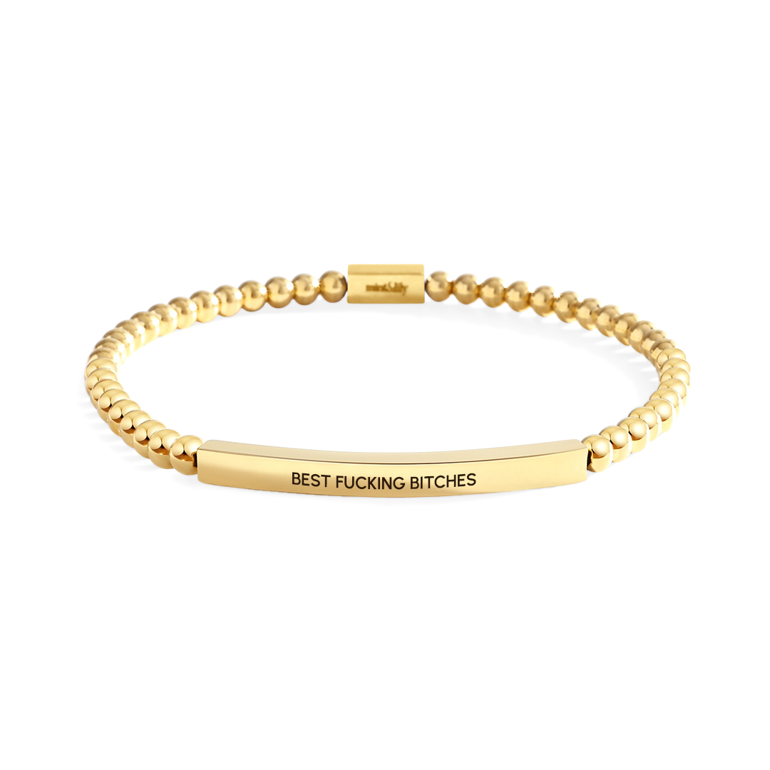 Gold beaded bracelet with engraved text on a white background