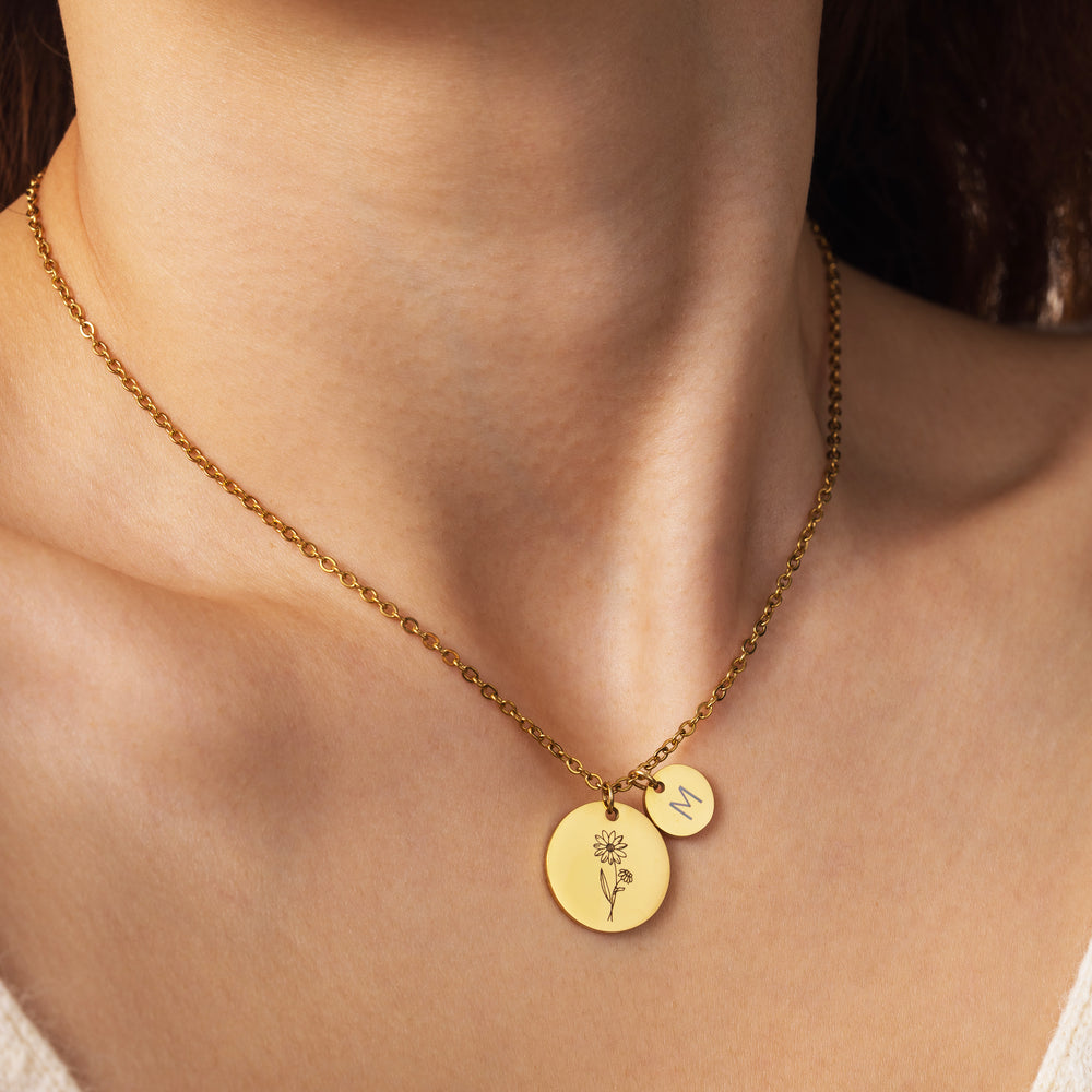 Close-up of a model wearing the Birth Flower Initial Necklace with its flower disc and initial disc pendant.