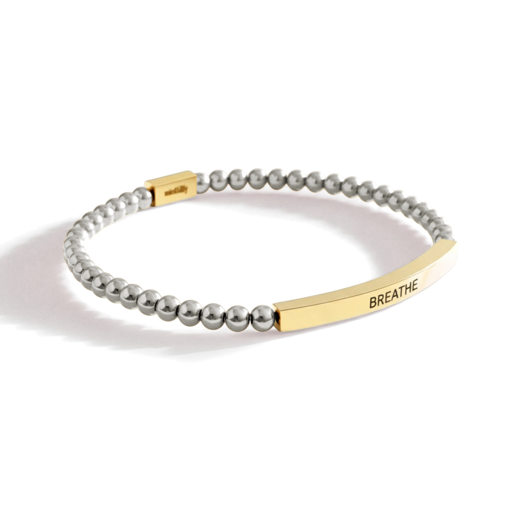 Bracelet with gold bar and gray beads on a white background