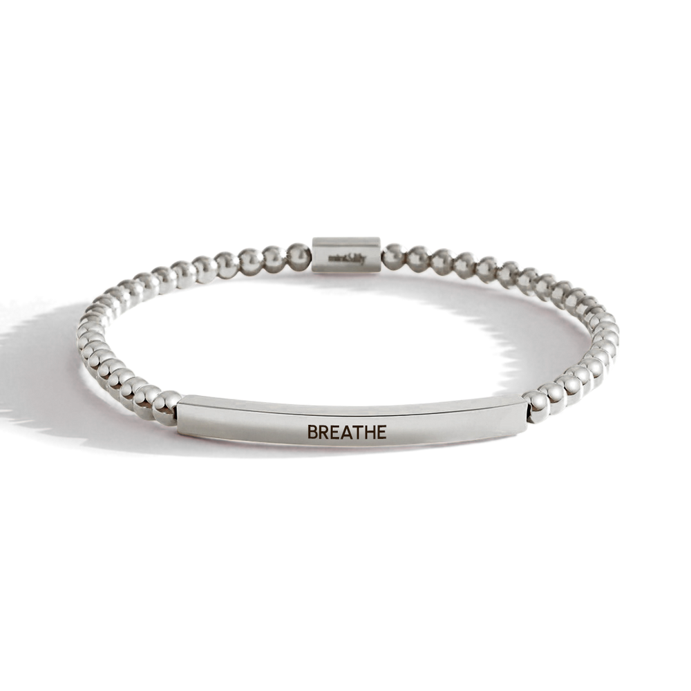 Silver beaded bracelet with a bar section engraved with 'BREATHE' on a white background