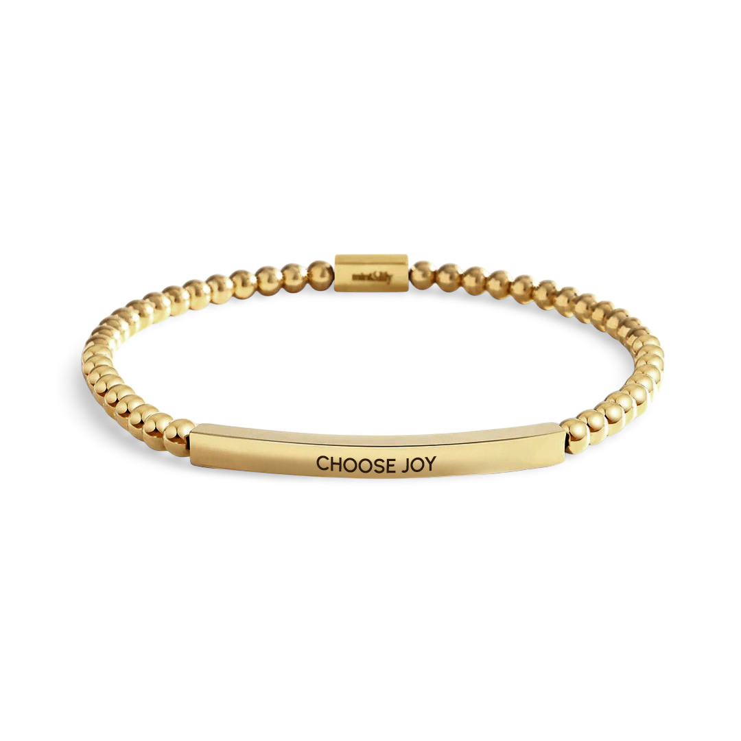 Gold bracelet with 'CHOOSE JOY' engraving on a white background
