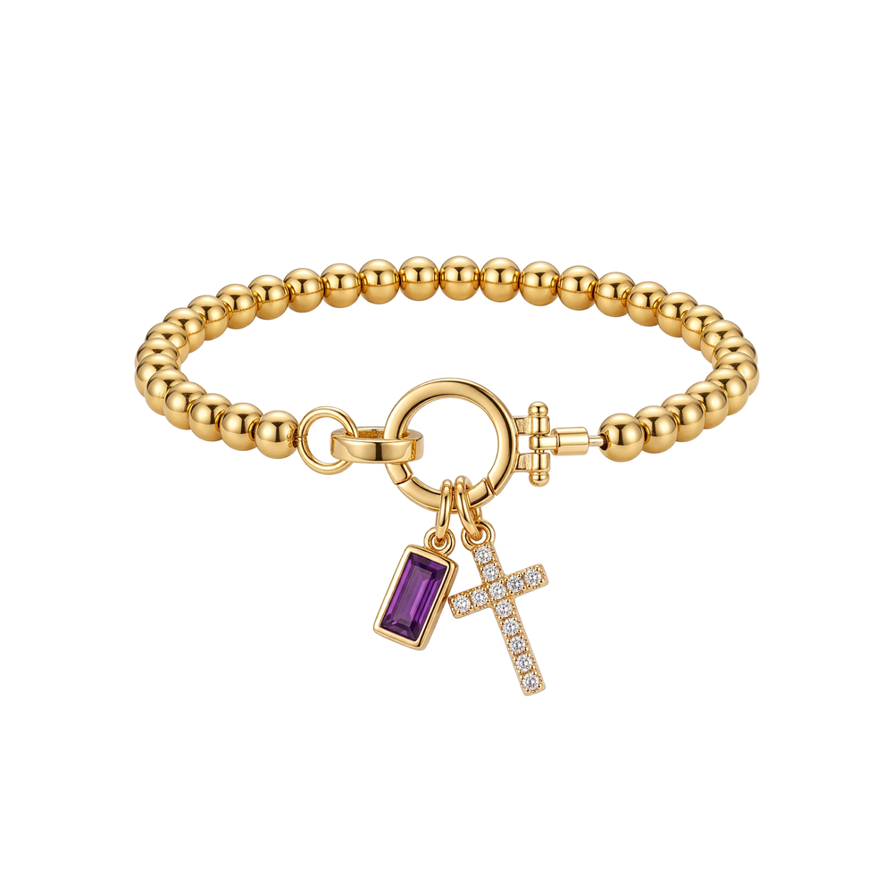 Flat lay of the Cross Charm Birthstone Bracelet with June alexandrite birthstone charm.