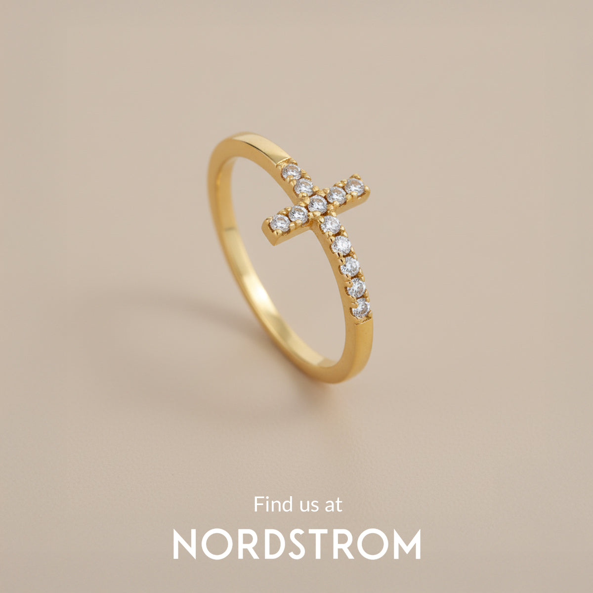 Gold ring with diamond cross design on a beige background, Nordstrom branding visible.