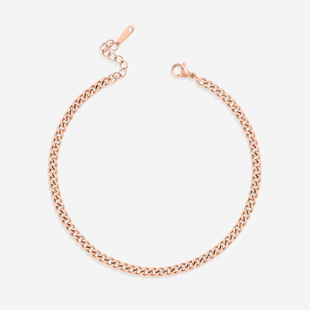 A gold curb chain anklet on a white background.