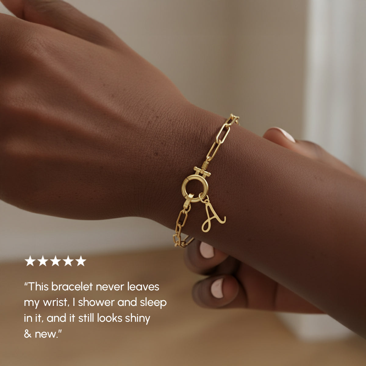 Gold bracelet on a wrist with a neutral background