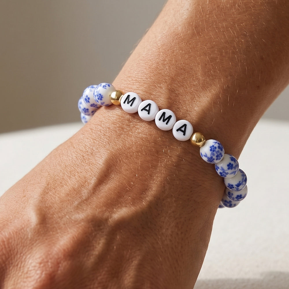 Bracelet with 'MAMA' beads on a wrist against a neutral background