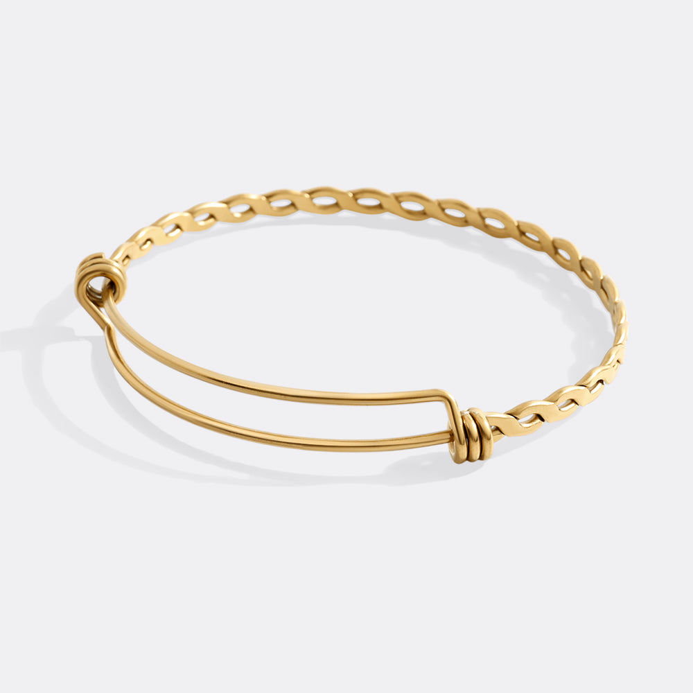 Gold bracelet on a light gray background