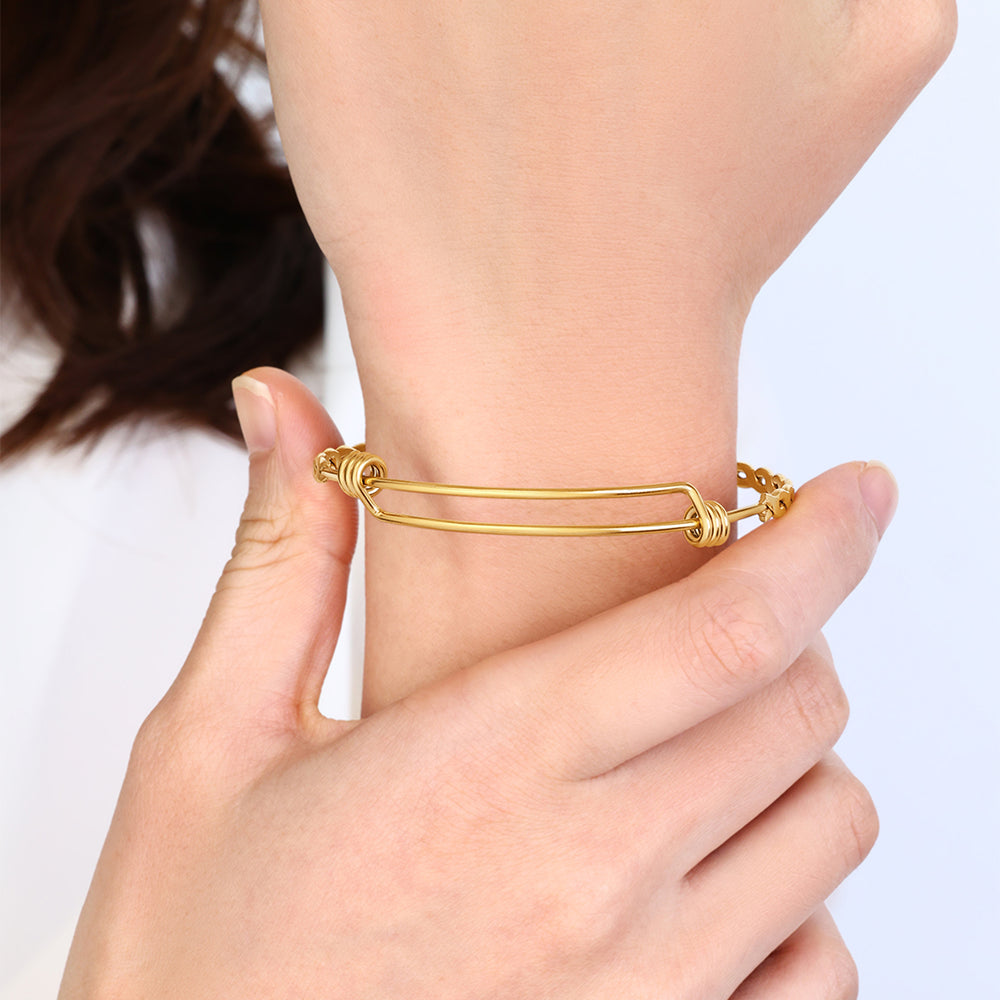 Gold bracelet on a wrist with a blurred background