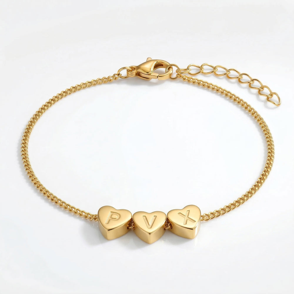 Gold bracelet with heart-shaped charms on a white background