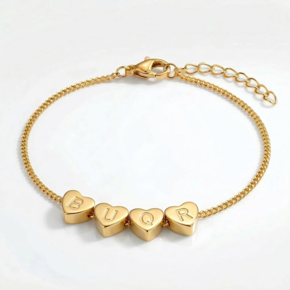 Gold bracelet with heart-shaped charms on a white background