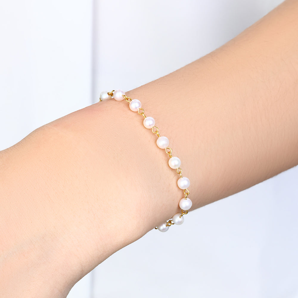 Pearl bracelet on a person's wrist against a white background
