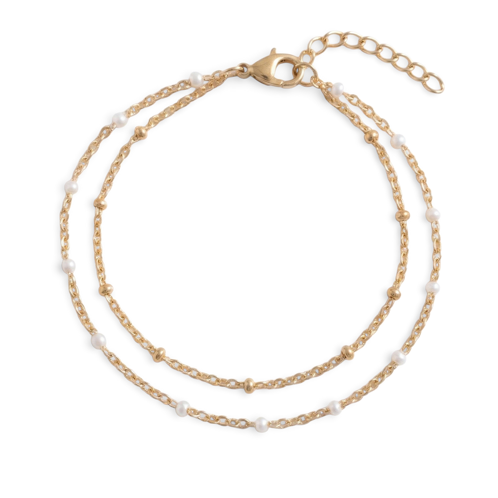 An elegant double chain bracelet accented with fine white accents designed for a refined, understated glow. Perfect for effortless everyday luxury.