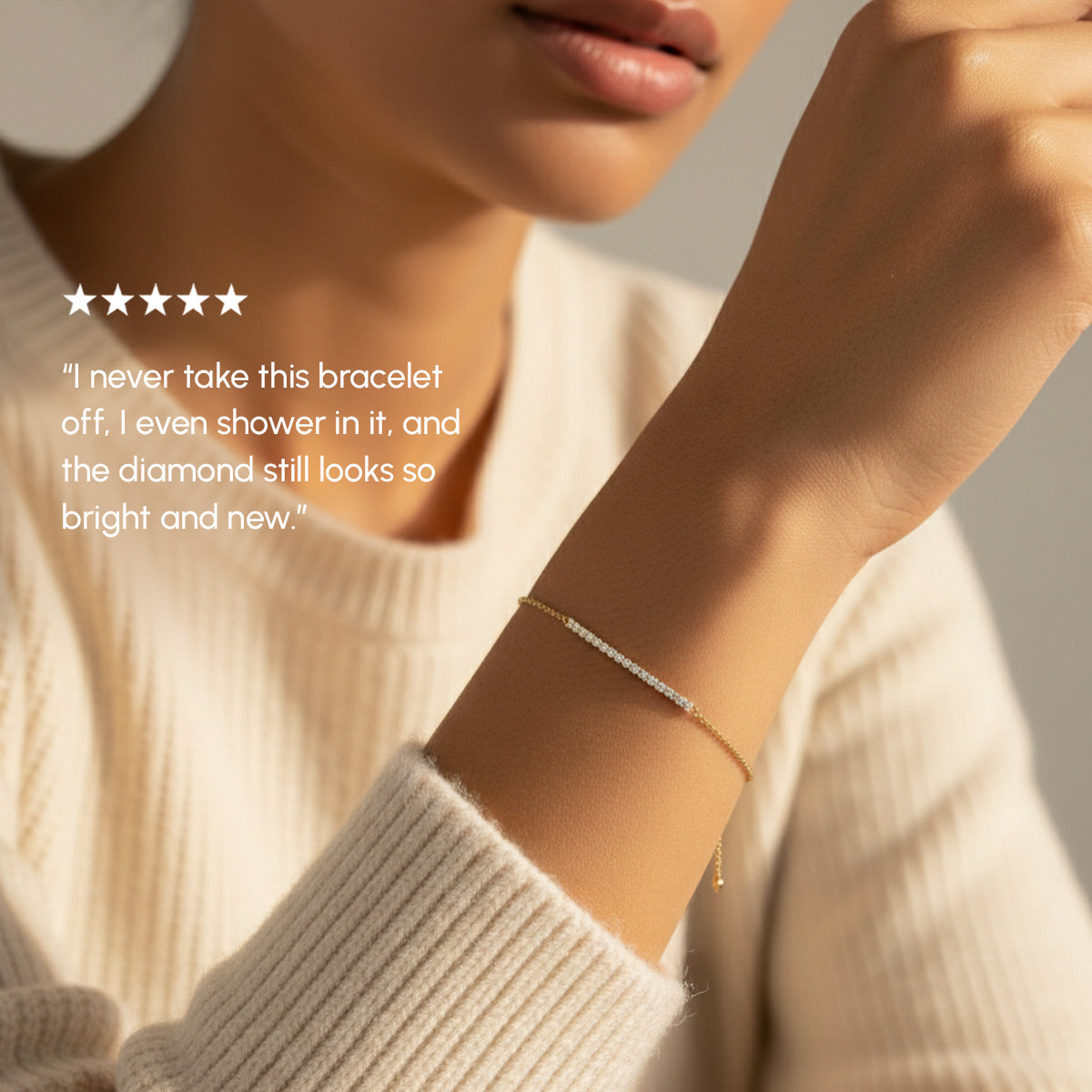 Person wearing a gold bracelet with a neutral background