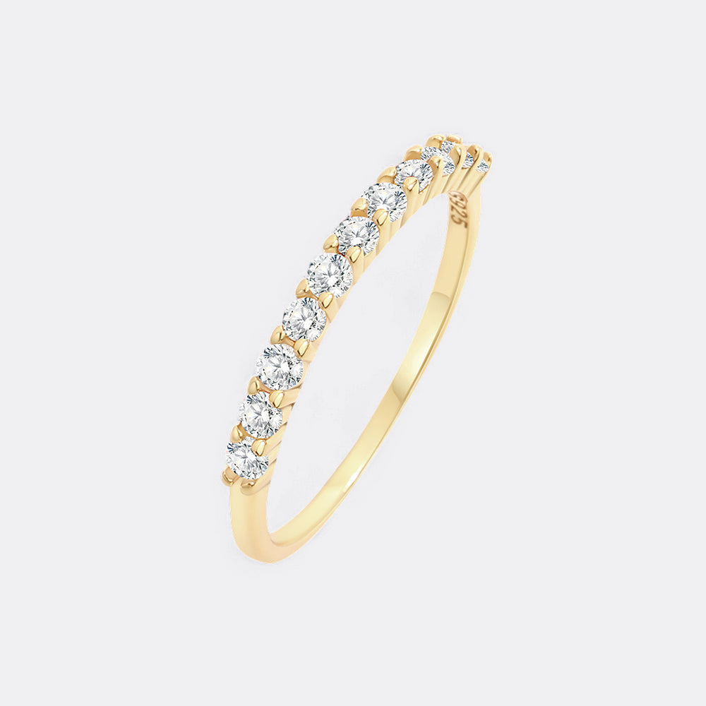 Gold ring with diamonds on a light gray background