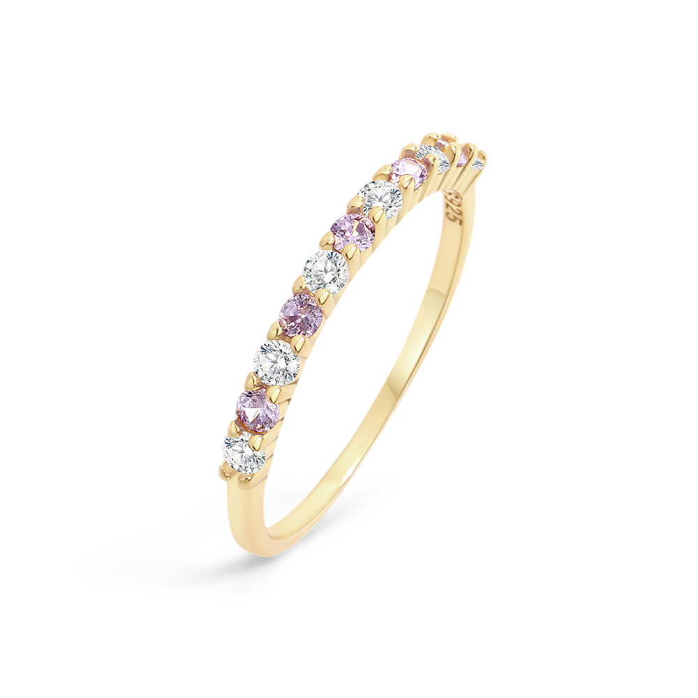 Gold ring with pink and clear gemstones on a light gray background