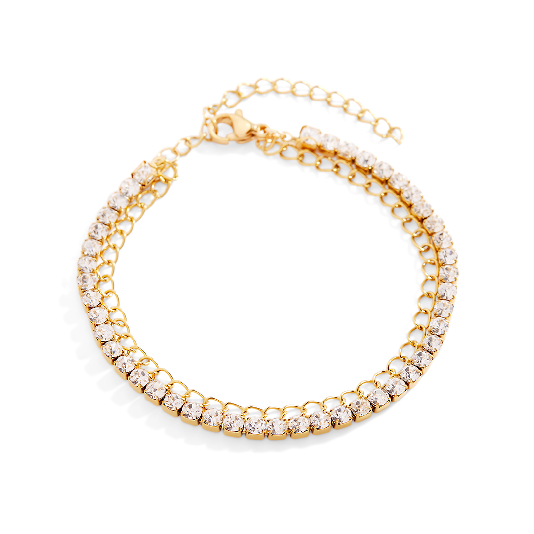 Gold bracelet with clear gemstones on a light gray background