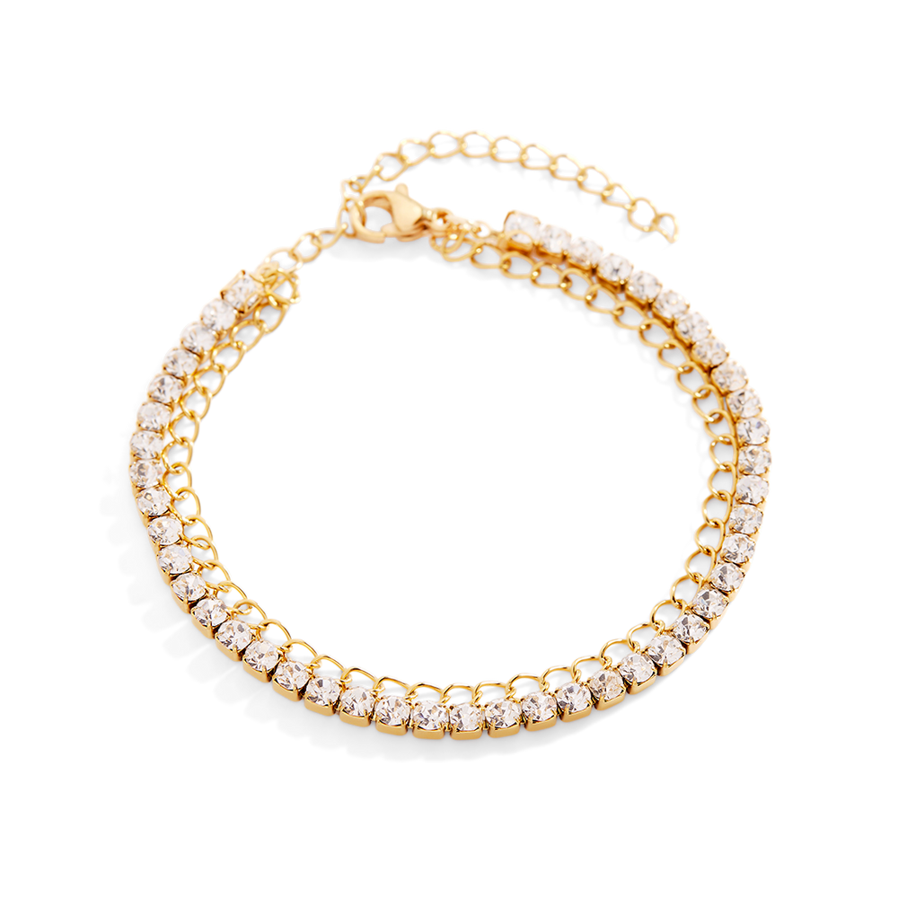 Gold bracelet with clear gemstones on a light gray background