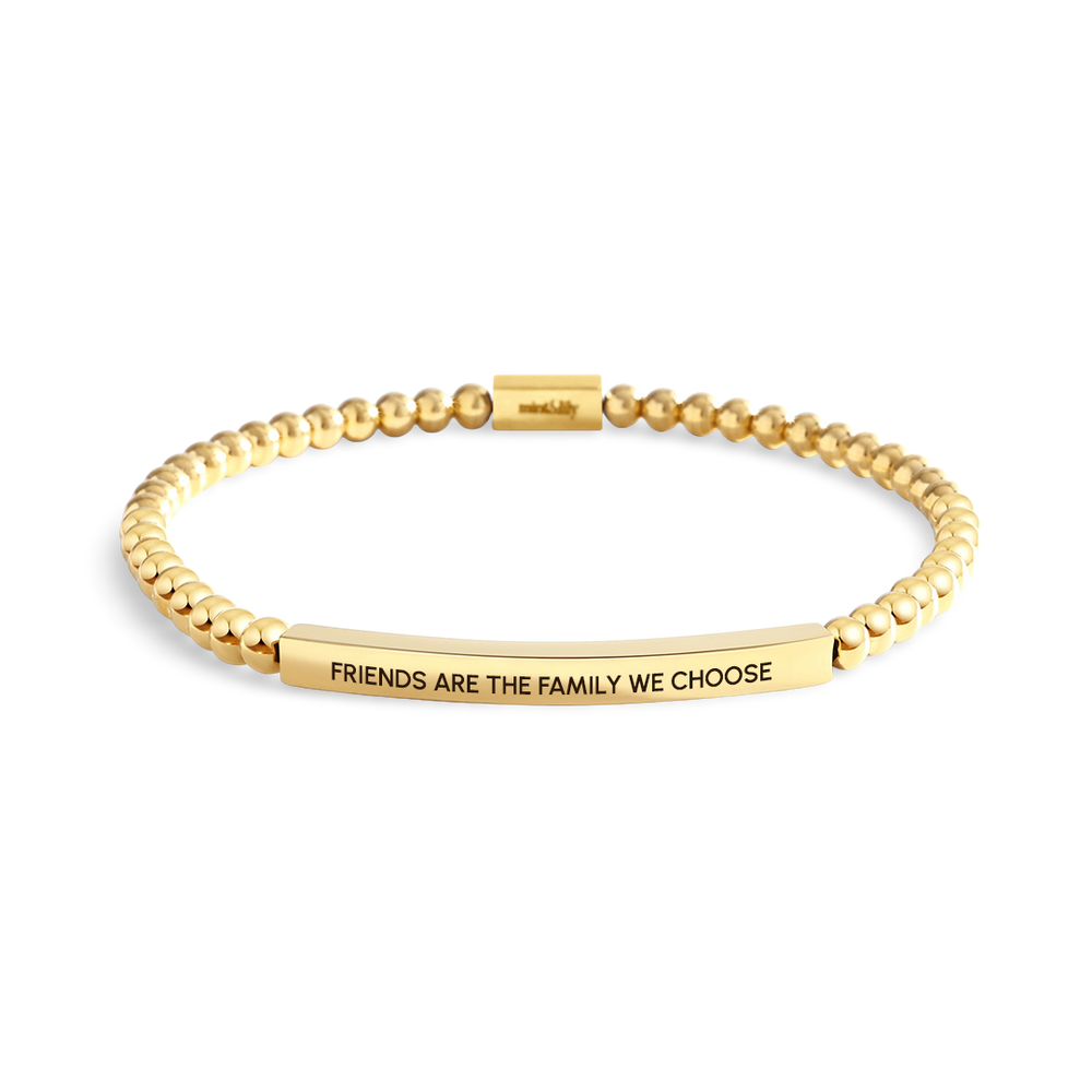 Gold bracelet with engraved message on a white background
