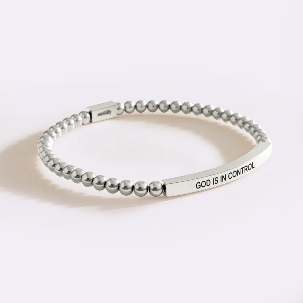 Silver beaded bracelet with 'GOD IS IN CONTROL' engraving on a white background