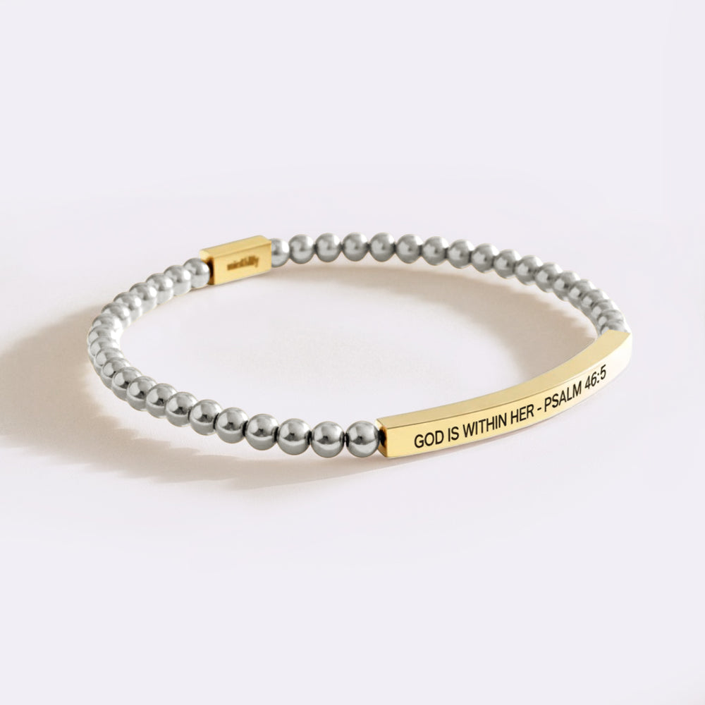 Bracelet with gold tag and gray beads on a white background