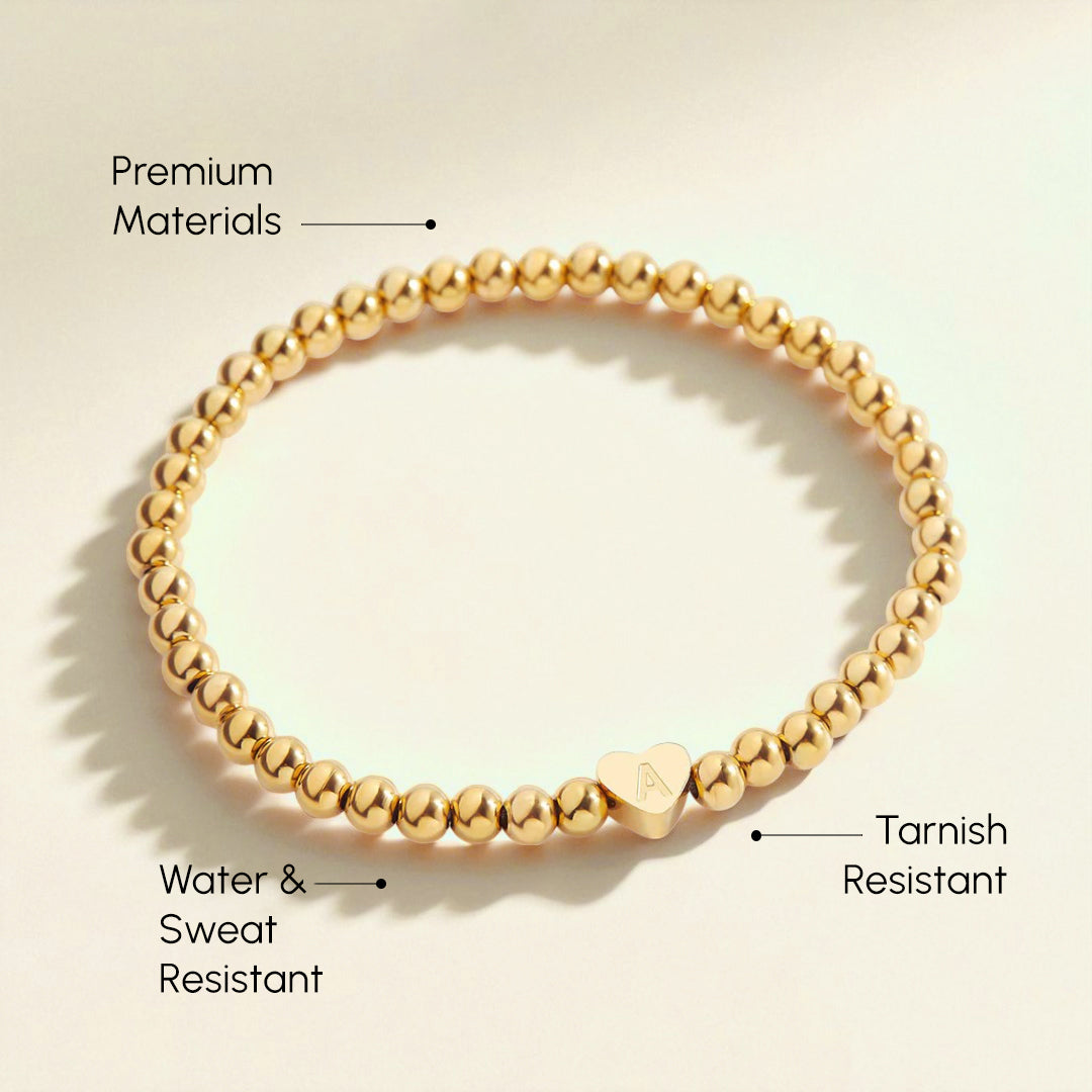 Gold beaded bracelet with text highlighting features on a beige background