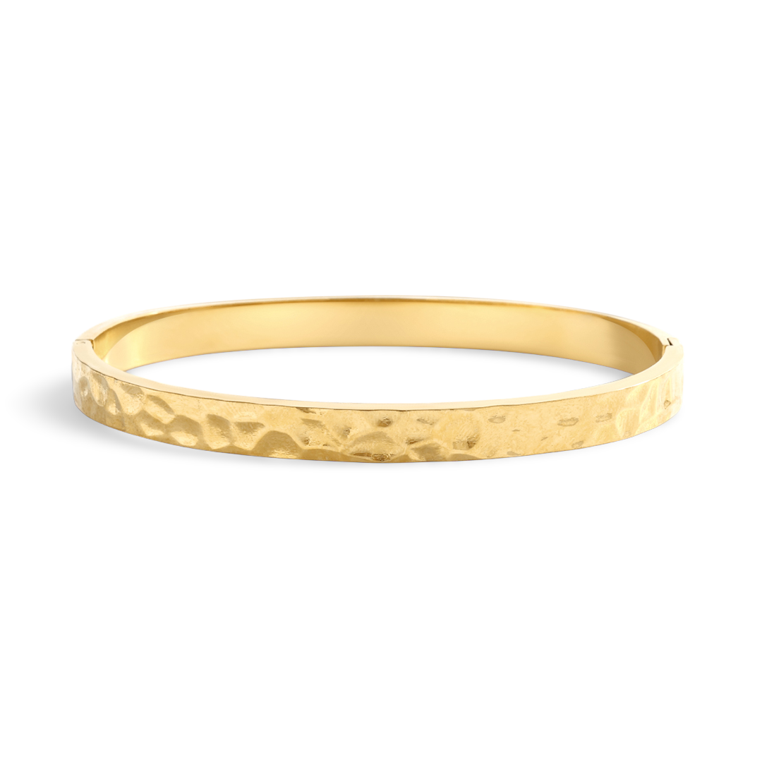 Gold bangle with a textured surface on a light gray background