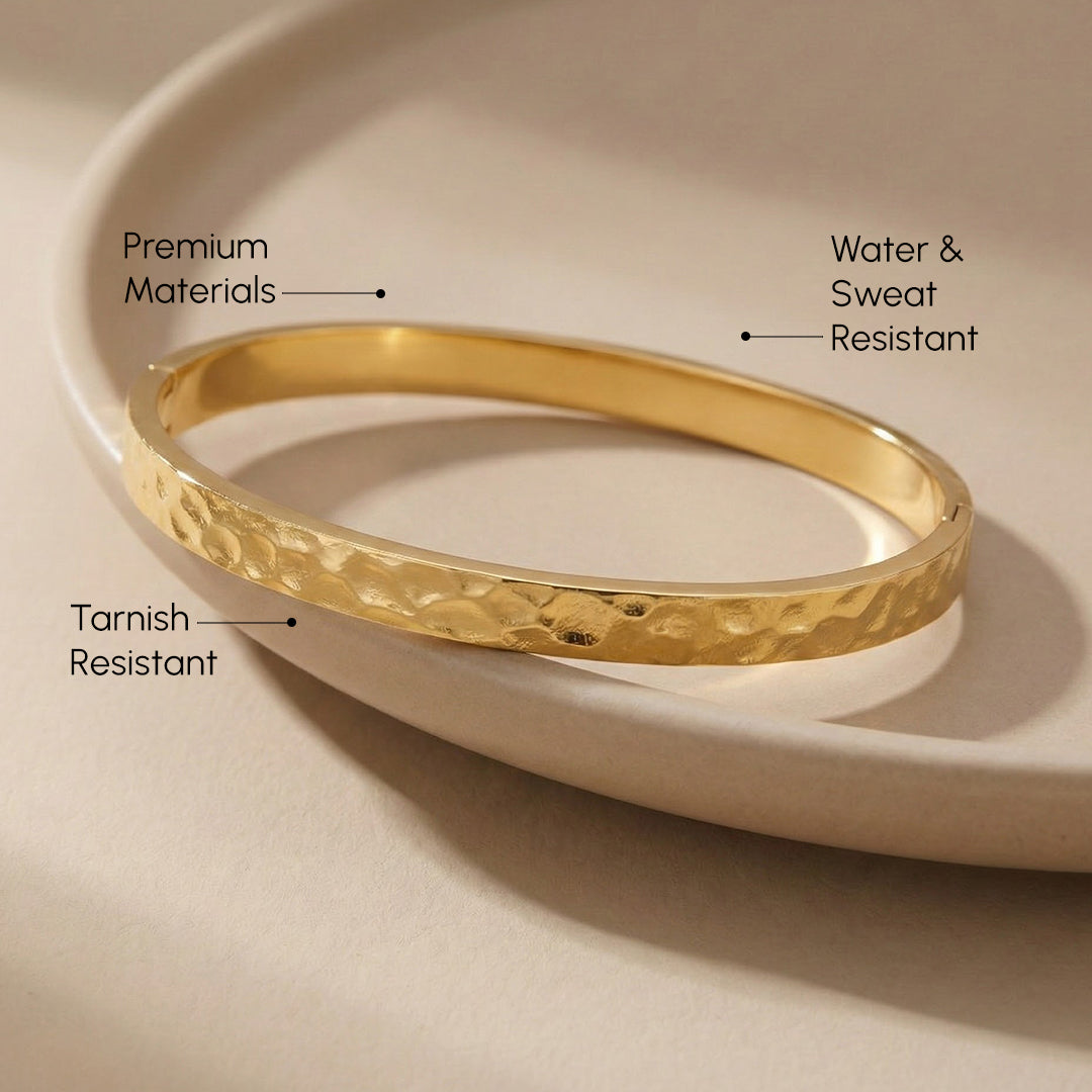 Gold bracelet on a beige plate with text highlighting features