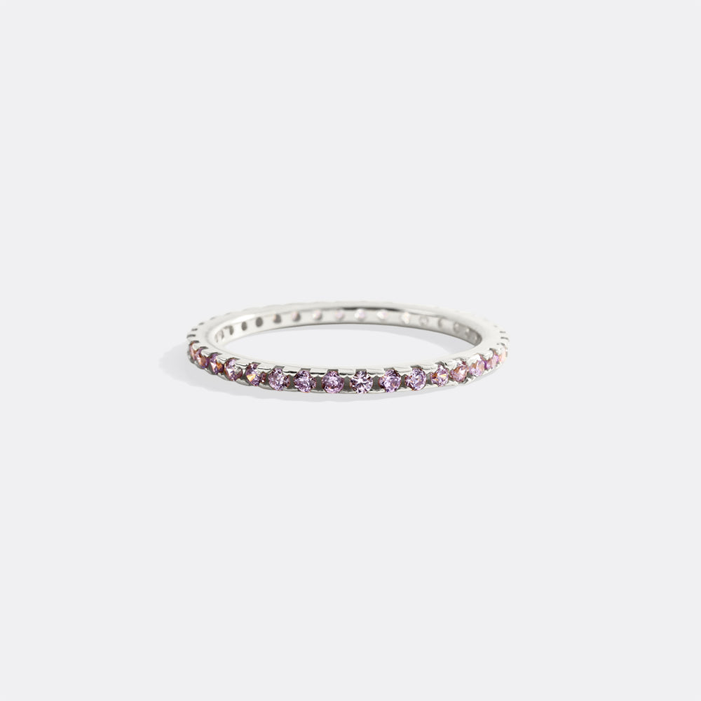 Silver ring with pink gemstones on a white background