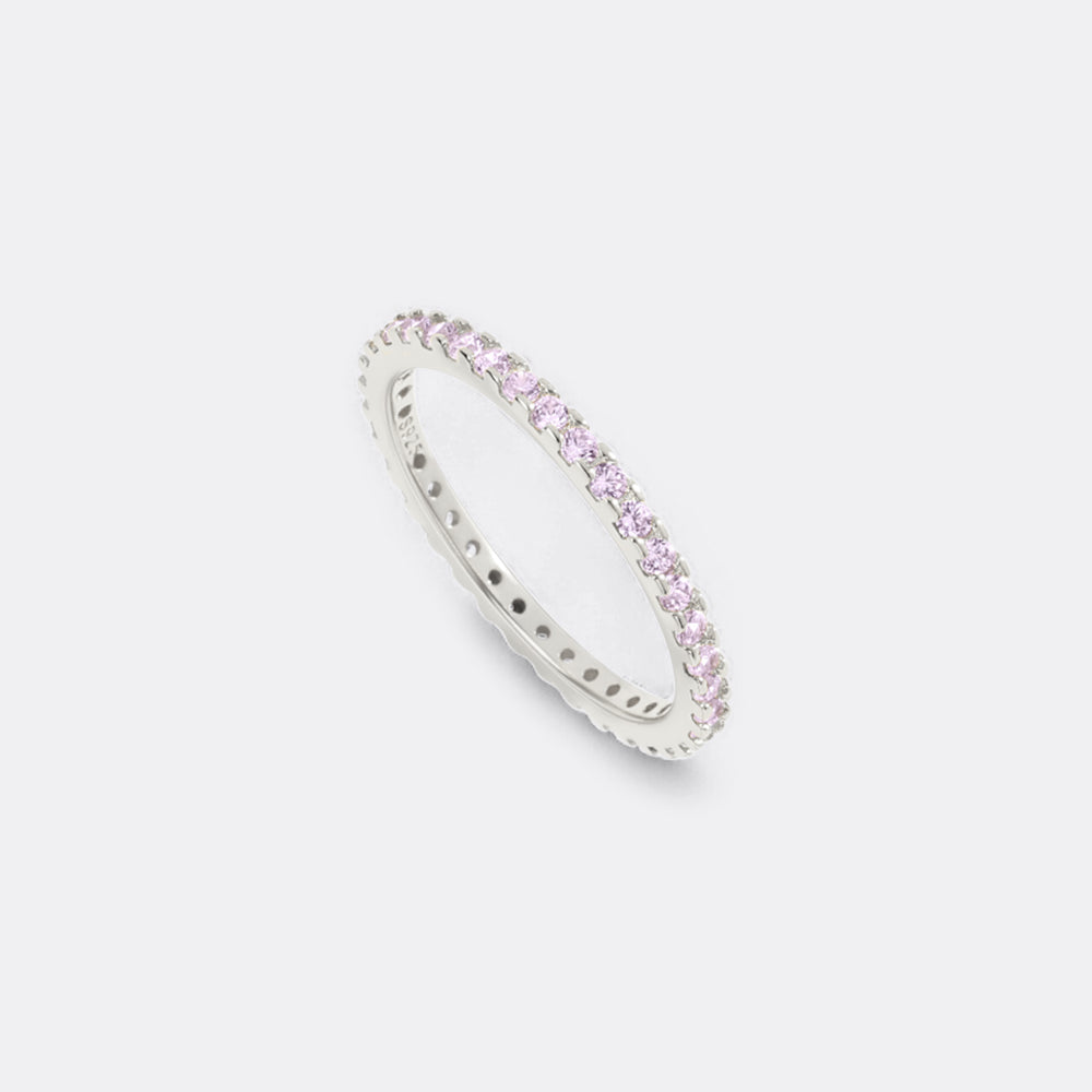 Silver ring with pink gemstones on a light gray background