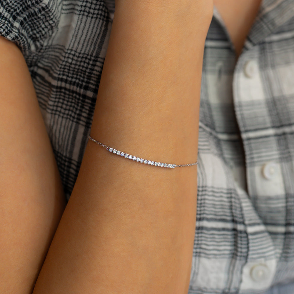 Silver bracelet on a wrist with a plaid shirt in the background