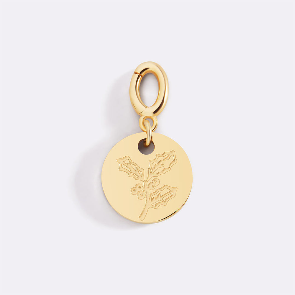 Gold pendant with floral design on a light gray background