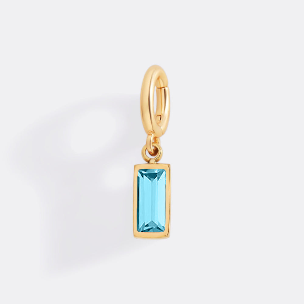 Gold pendant with a blue gemstone on a white background