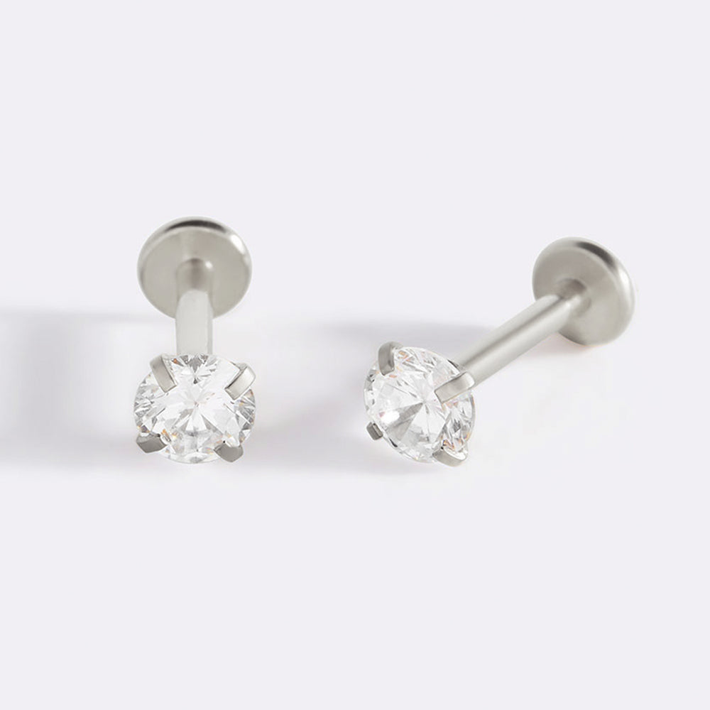 A pair of 18g flatback sleeper stud earrings with cubic zirconia stones, displayed against a black background.