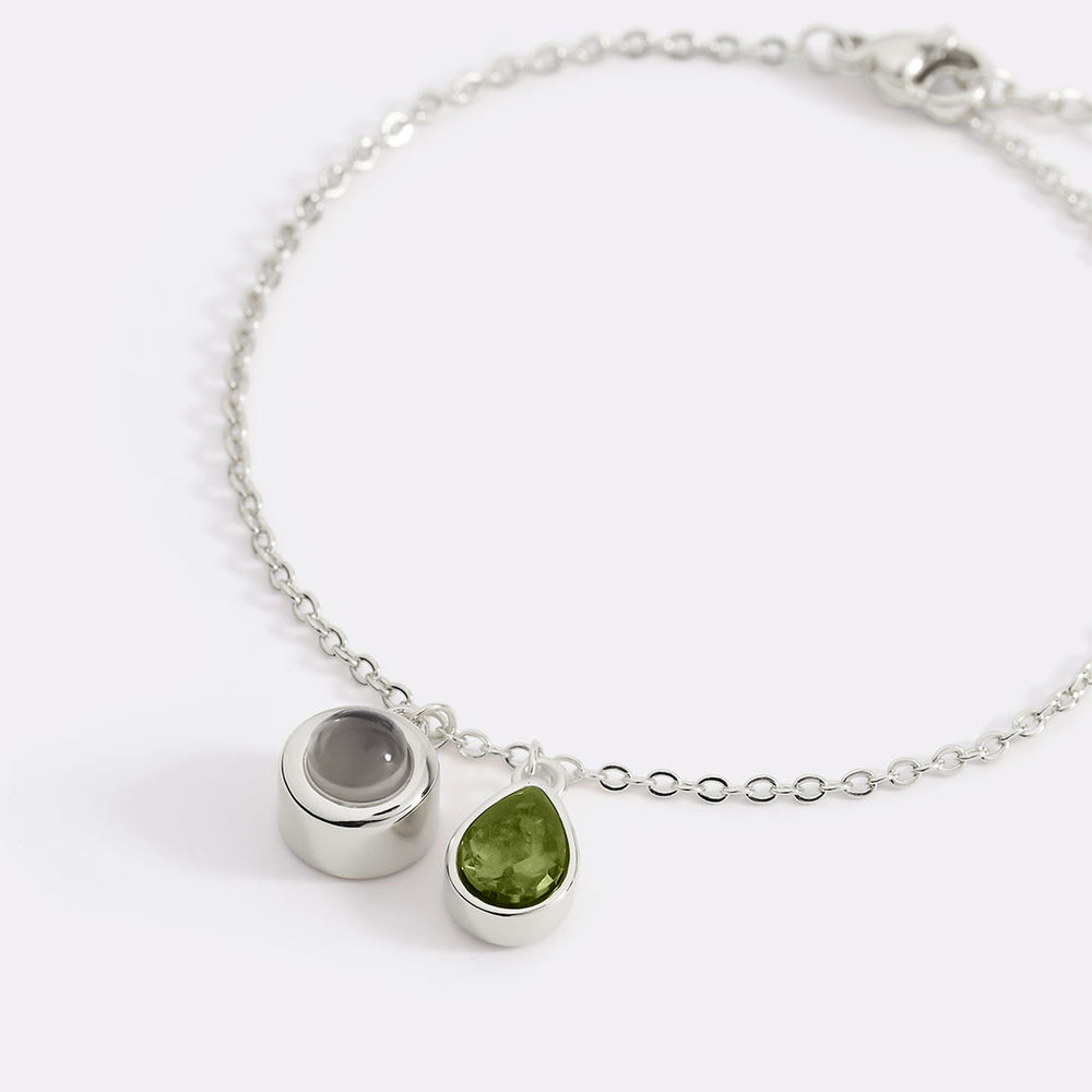 Silver bracelet with two gemstone charms on a white background