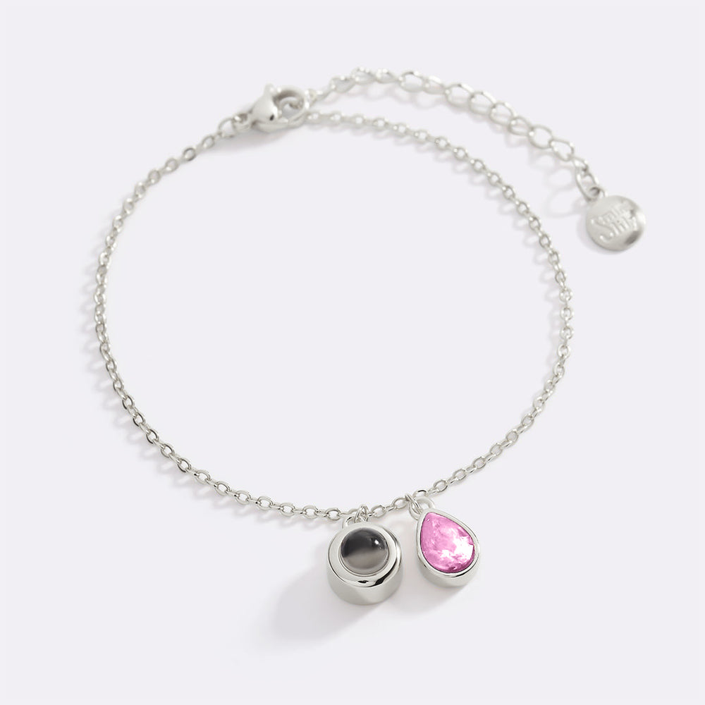 Silver bracelet with pink and black beads on a white background