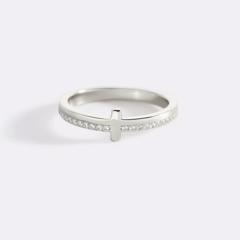 Silver ring with a cross design on a white background