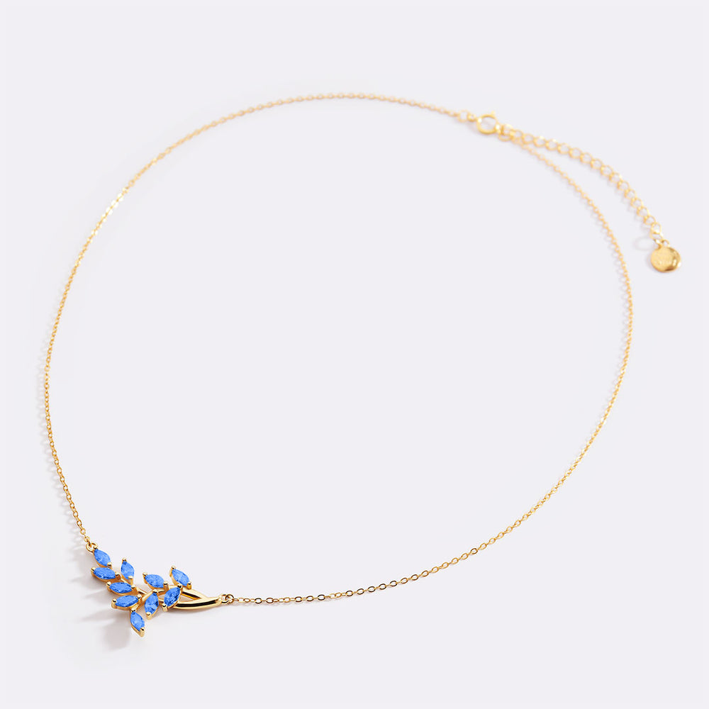 Gold necklace with blue stones on a light gray background