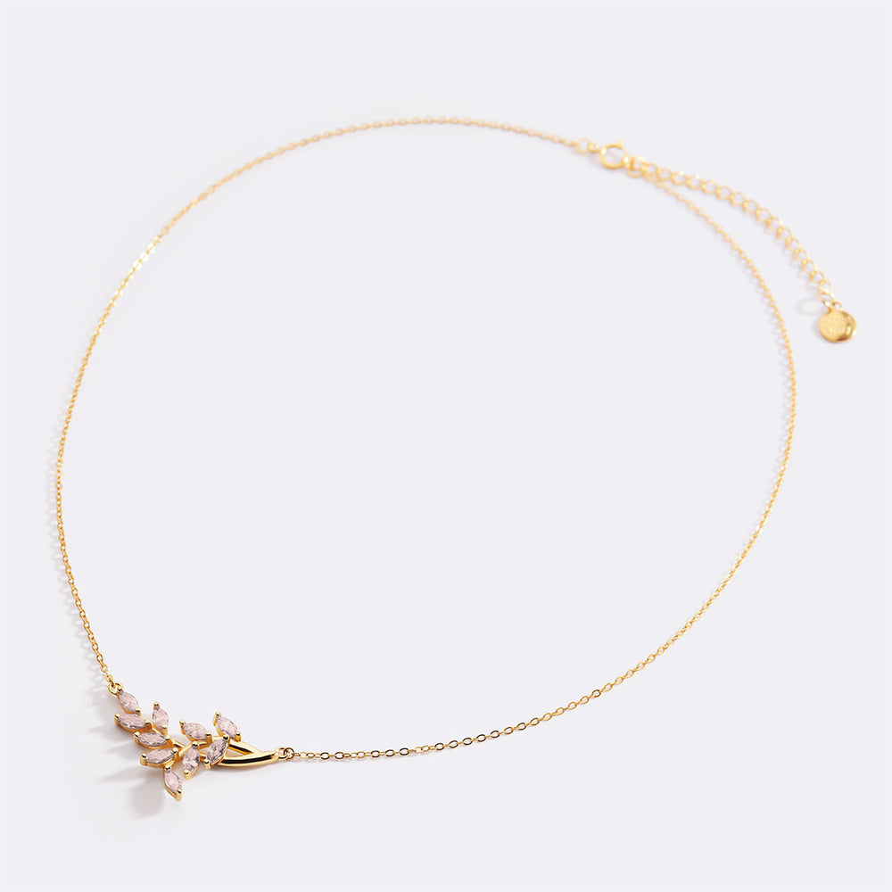 Gold necklace with a delicate pendant on a light gray background