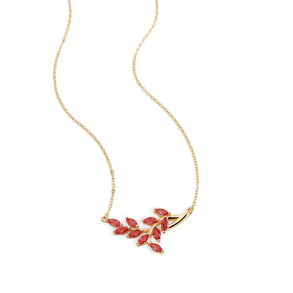 Gold necklace with red gemstones on a light gray background