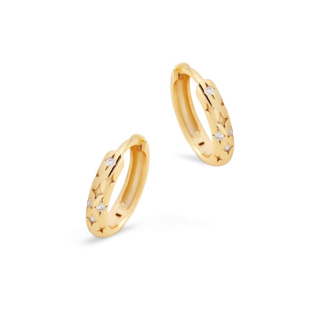Gold hoop earrings with small diamonds on a light gray background