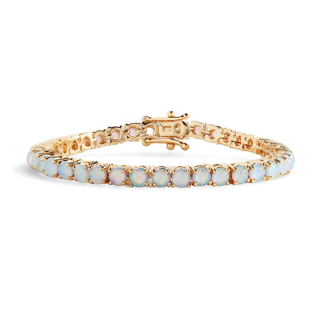 Gold bracelet with white stones on a light gray background