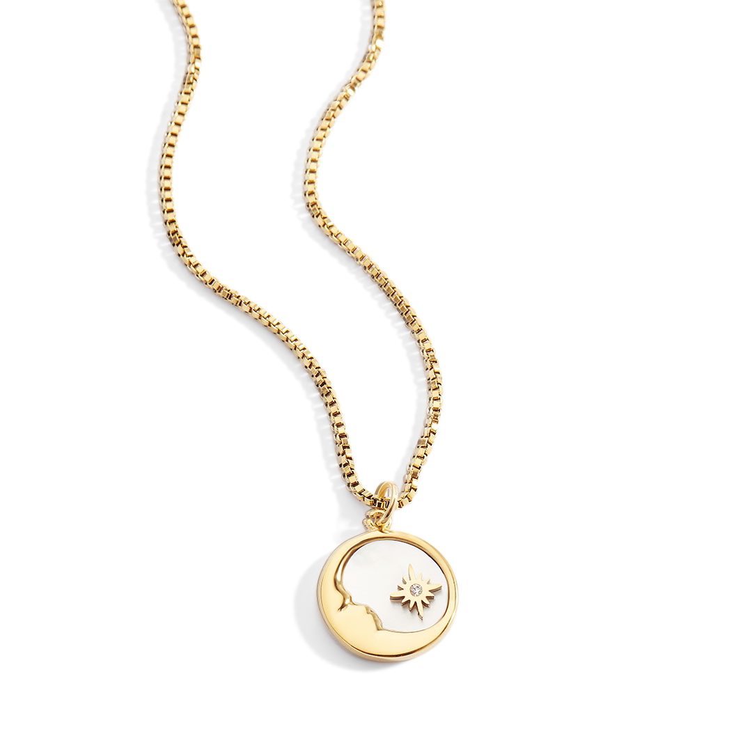 Gold necklace with a pendant on a light gray background