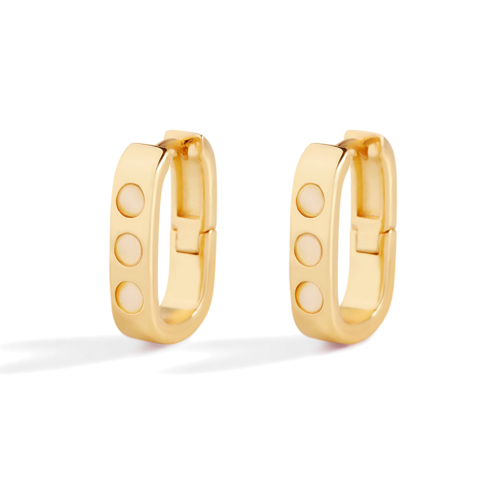 Gold hoop earrings with circular designs on a light gray background
