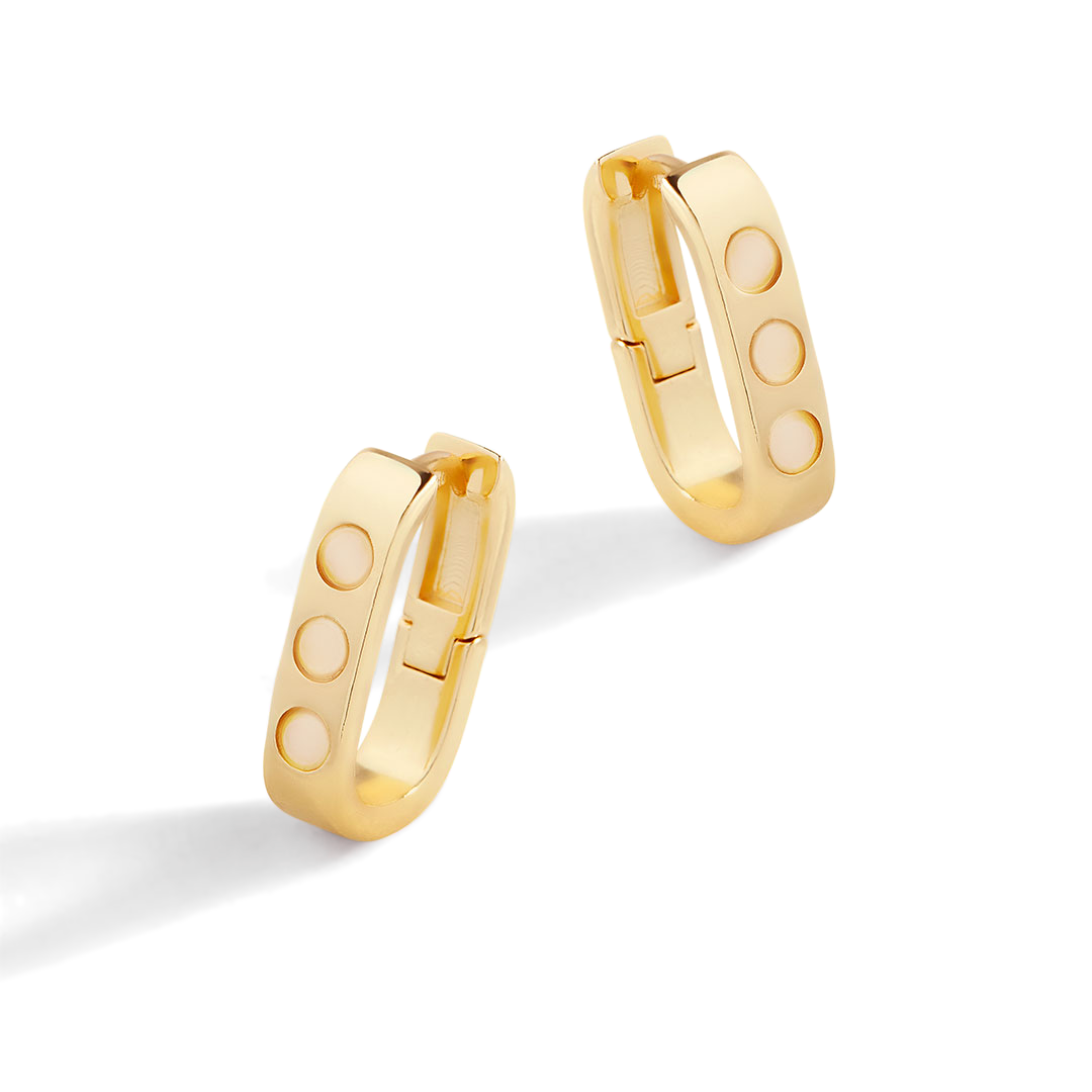 Gold hoop earrings with round cutouts on a light gray background